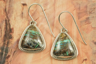 Genuine Sunnyside Turquoise set in Sterling Silver French Wire Earrings. The matrix on this rare stone is outstanding. The Sunnyside mine is located in northern Nevada near the town of Tuscarora in the Tuscarora mountain range. The mine is no longer in operation as it has become part of a gold mining operation and a privately owned ranch. The Sunnyside mine was mined mostly in the 70's. You won't find much of this great turquoise around anymore except for old stashes. Created by Navajo Artist Milton Lee. Signed. 
